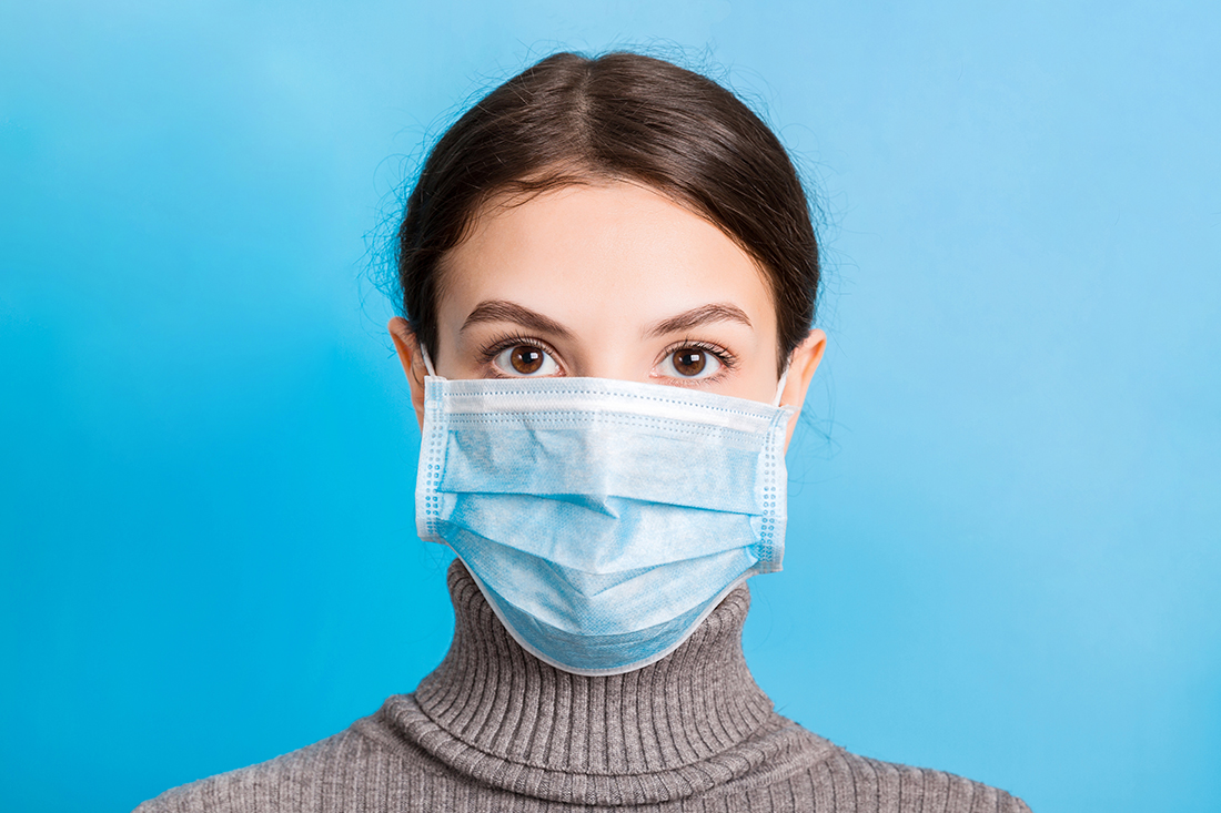 medidas precaución virus covid 19 Retrato de mujer joven con máscara médica en azul.